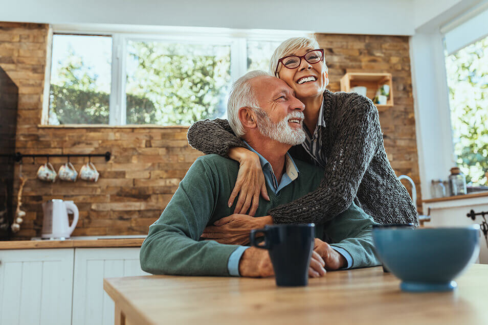Older couple hugging in kitchen