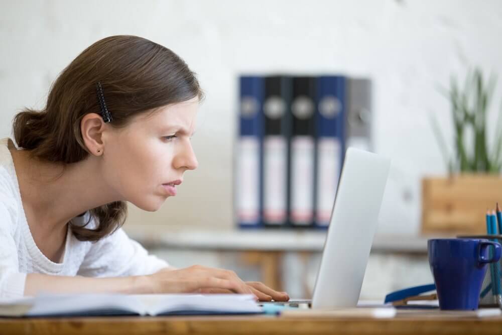 Woman straining to look at computer screen