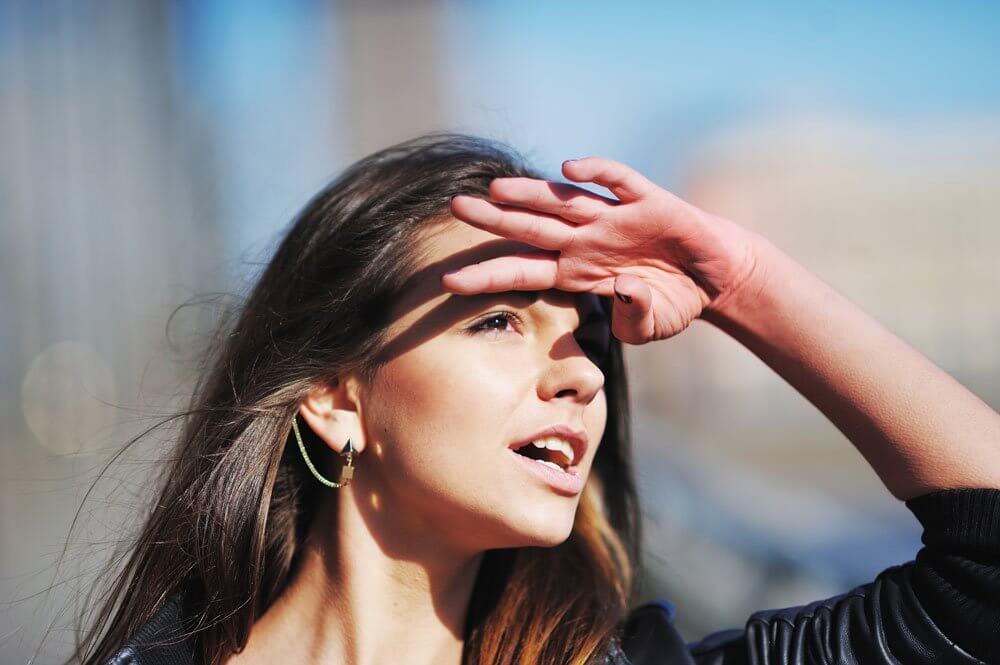 Woman shielding her eye from the sun