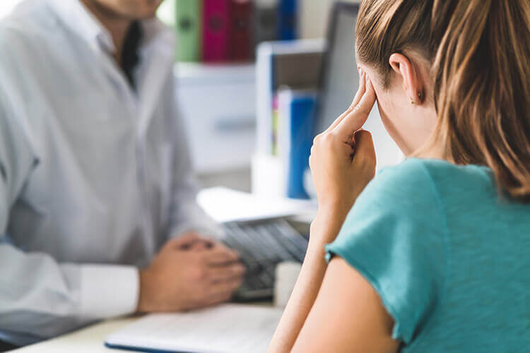 Woman at doctor office with headache
